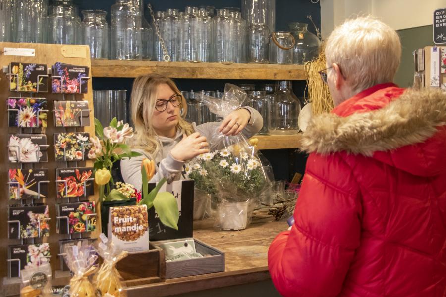 stagiaire verkoopt bloemen 