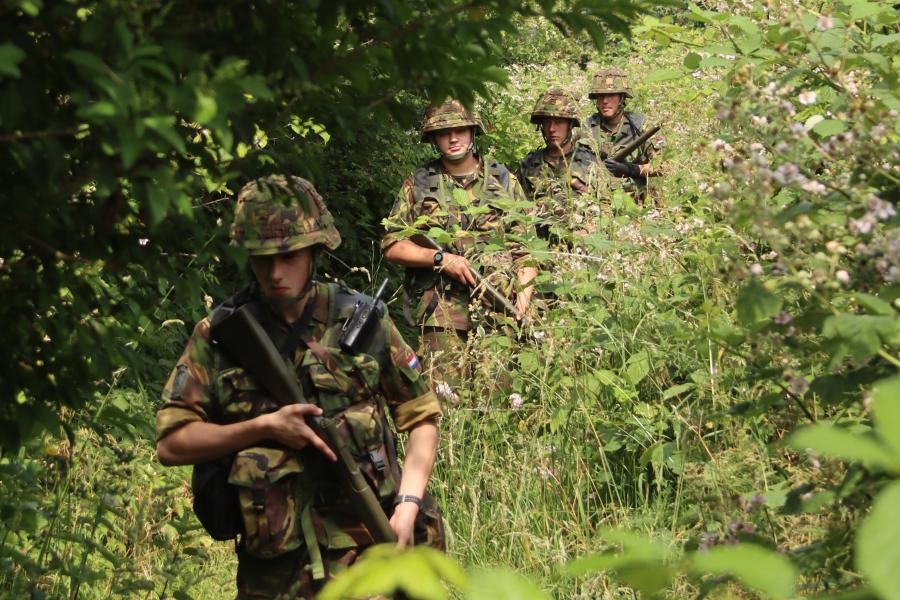 studenten lopen in rij buiten door het bos 