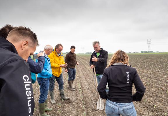 Peter Appelman en mensen staan in een weiland 