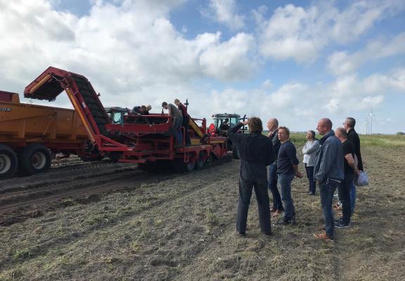 Mensen bekijken boerderij machine 