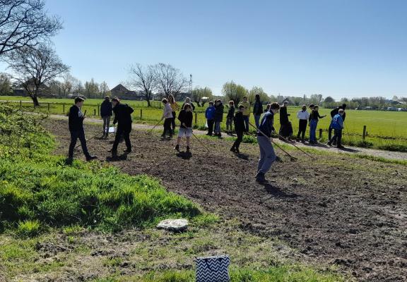 Leerlingen lopen door weiland