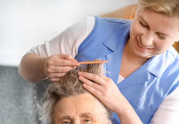 oudere vrouw haar haren worden gekamd 